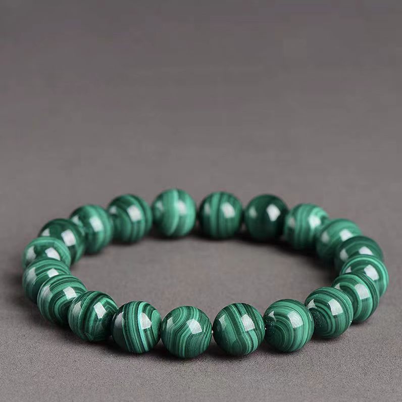 Green beaded bracelet on a gray background