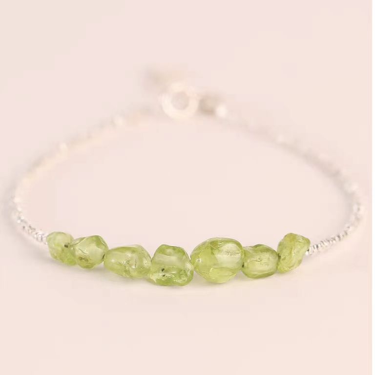 Bracelet with green beads on a light background