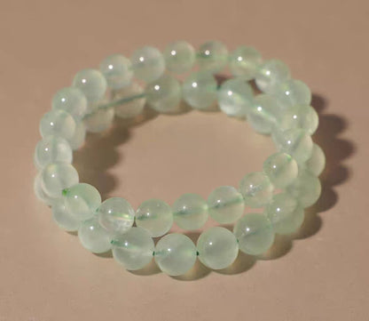 Green beaded bracelet on a beige background