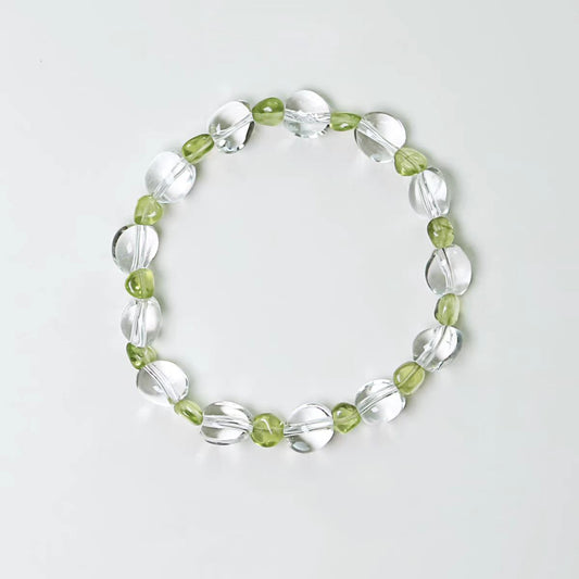 Bracelet with green and clear beads on a light gray background