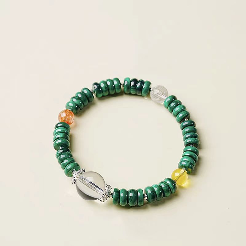 Green beaded bracelet with colorful accents on a beige background