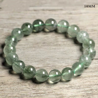 Green beaded bracelet on a wooden surface with '10MM' text.