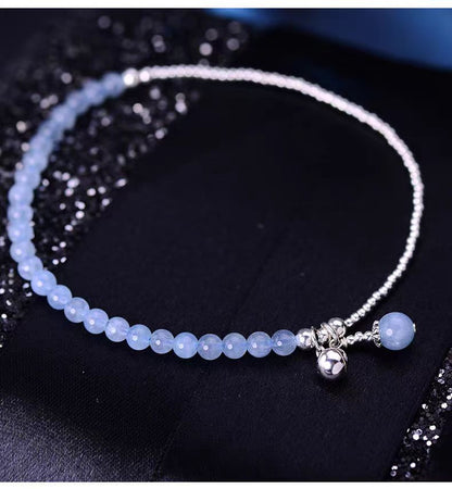 Bracelet with blue beads and silver accents on a dark fabric background