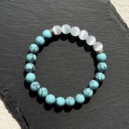 Turquoise and white beaded bracelet on a dark slate surface