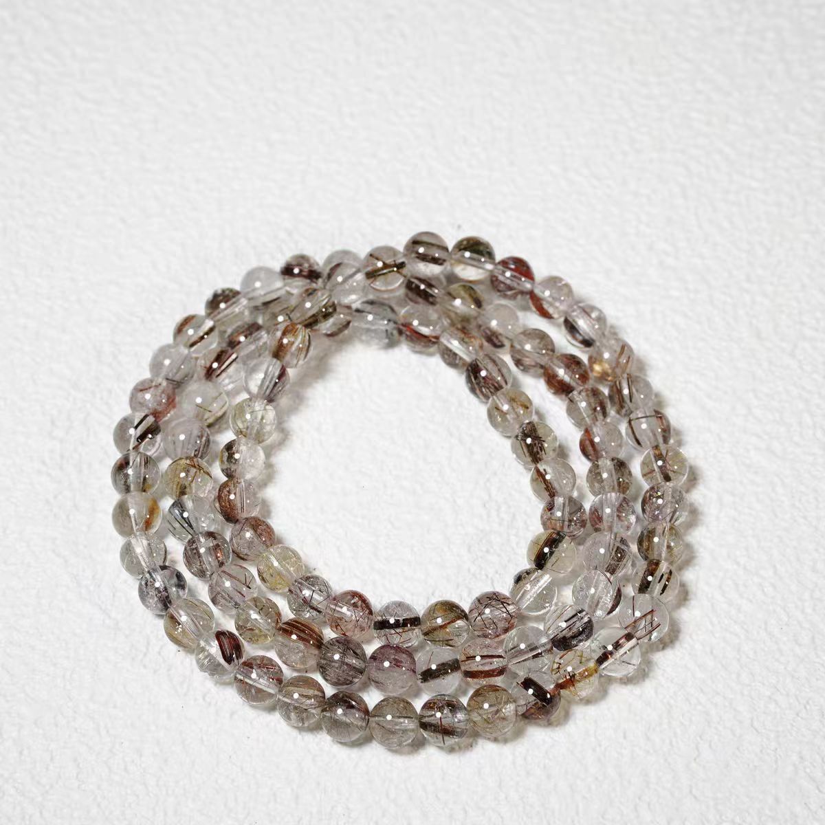 Stack of multicolored beaded bracelets on a white background