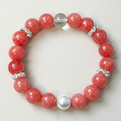 Bracelet with pink beads and a central pearl on a light background