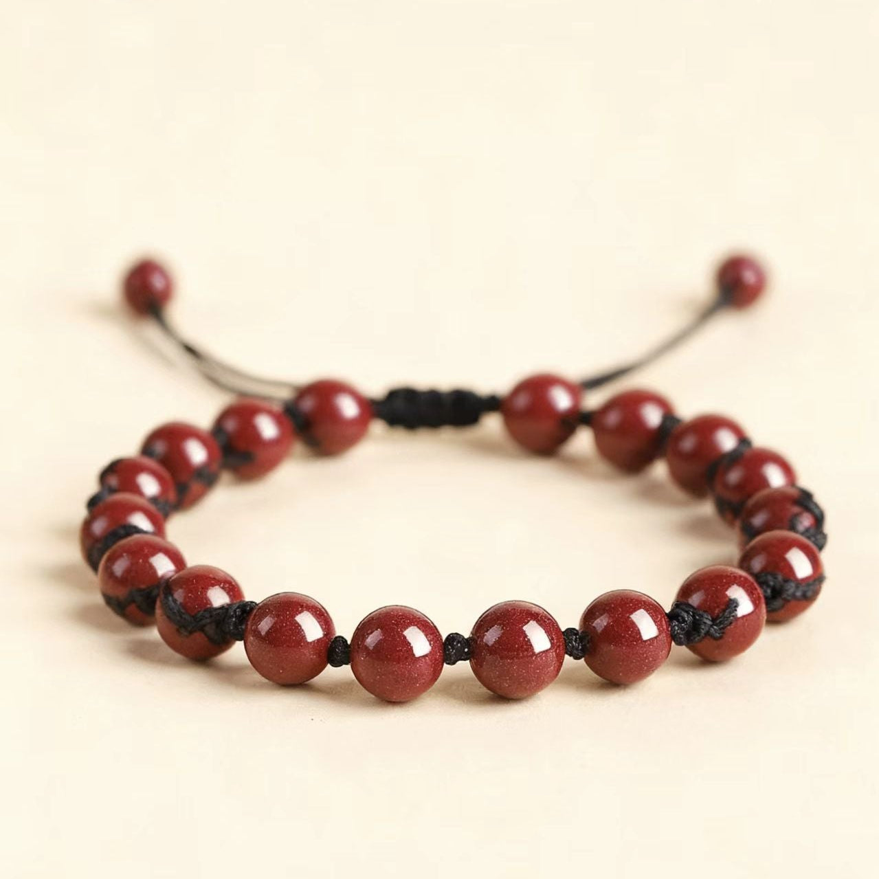 Red beaded bracelet on a beige background