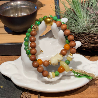 Stack of beaded bracelets on a white ceramic dish with a natural background